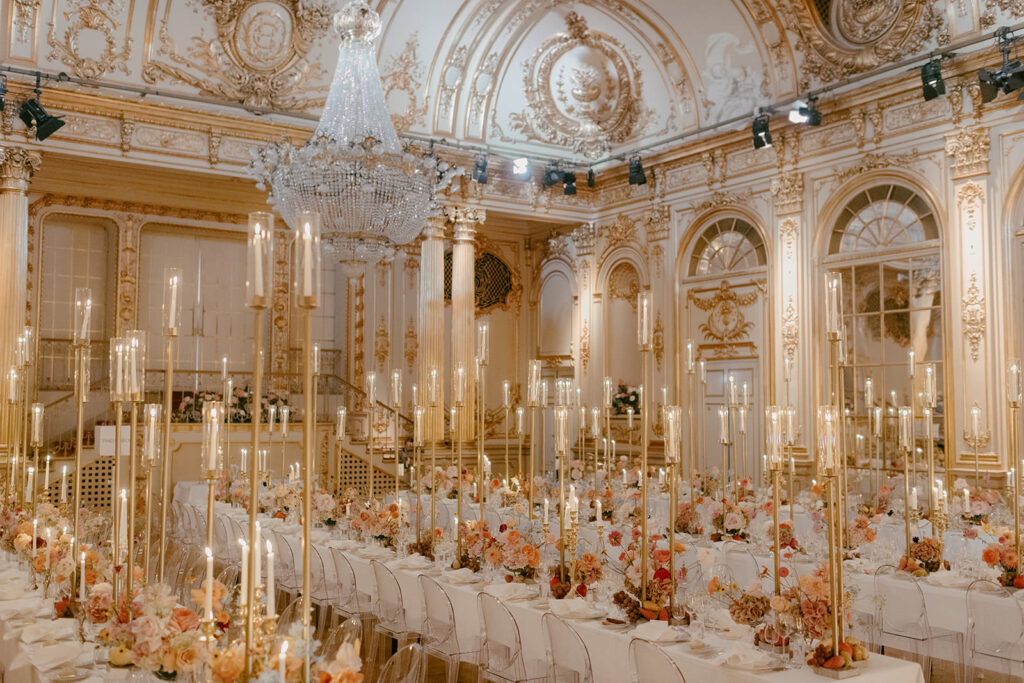 Luxurious wedding reception in the Hall of Mirrors at Grand Hôtel, Stockholm. Captured by wedding photographer Karin Lundin. The room glows with golden decor, white tablecloths, and hundreds of chandeliers, including a grand chandelier in the ceiling. Planned by WeddingPlanner Stockholm.