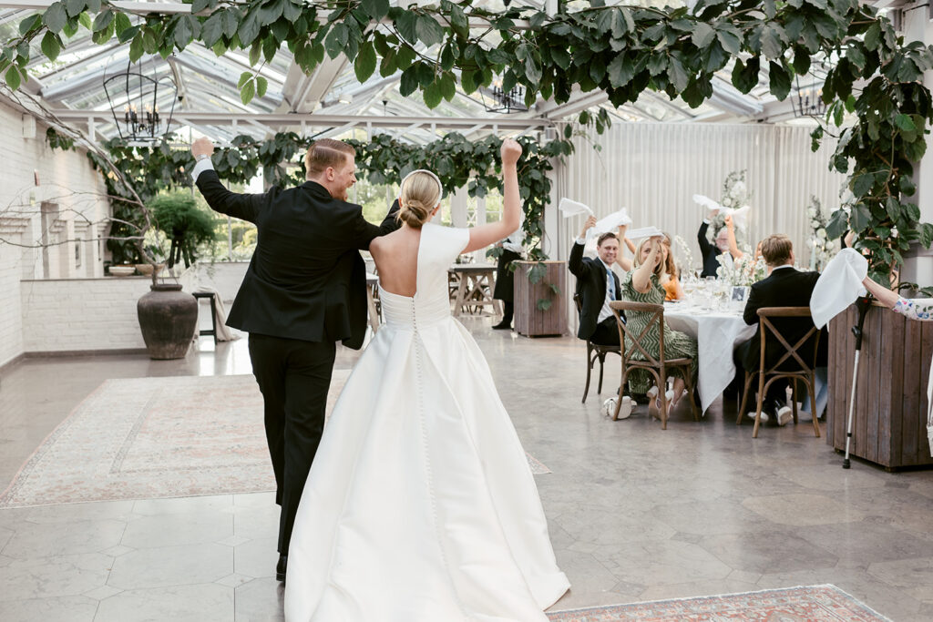 Wedding at Norrvikens trädgårdar 65 The couple dances into dinner under the glass roof as guests at round tables cheer