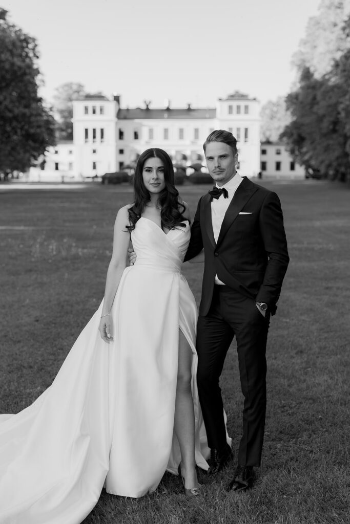 Black tie wedding at Rånäs Castle in Sweden, couple on the lawn in black and white