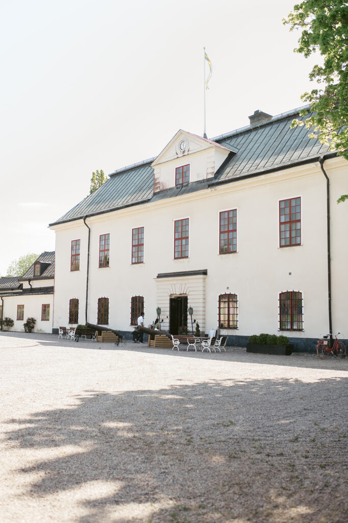 Häringe Slotts vita fasad med gröna fönsterluckor, svartvitt