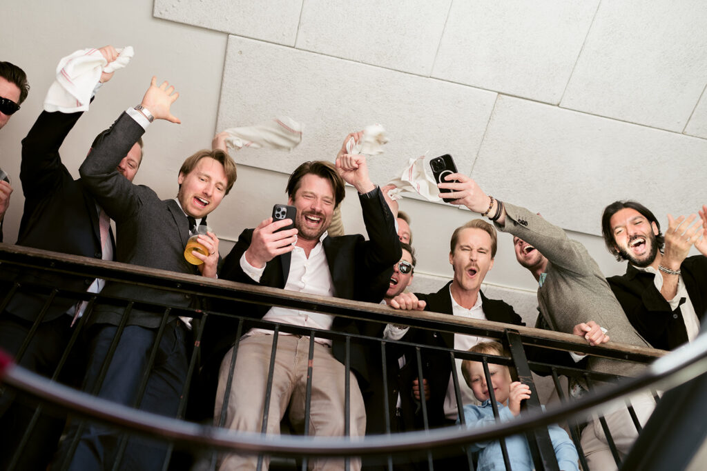 Bröllopsgäster tar selfies med brudpar i trappa, Stockholms Stadshus
