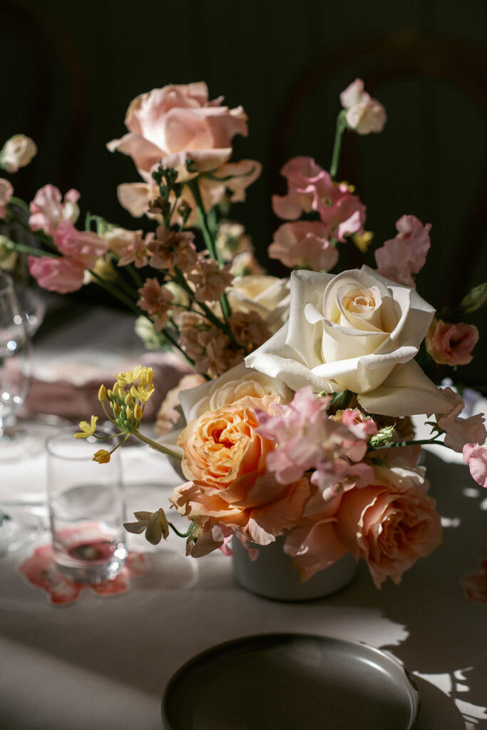 Close-up of a warm-toned floral arrangement with roses and autumn flowers at a Högberga Gård wedding