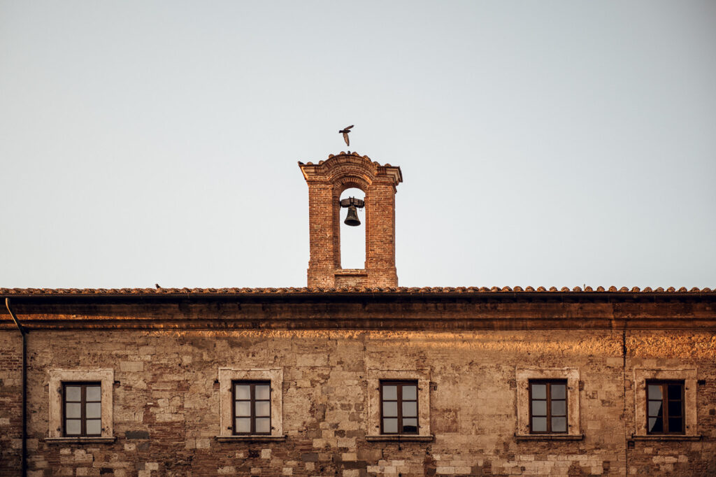 Stone bell tower and villa with cypress trees, Tuscan wedding venue