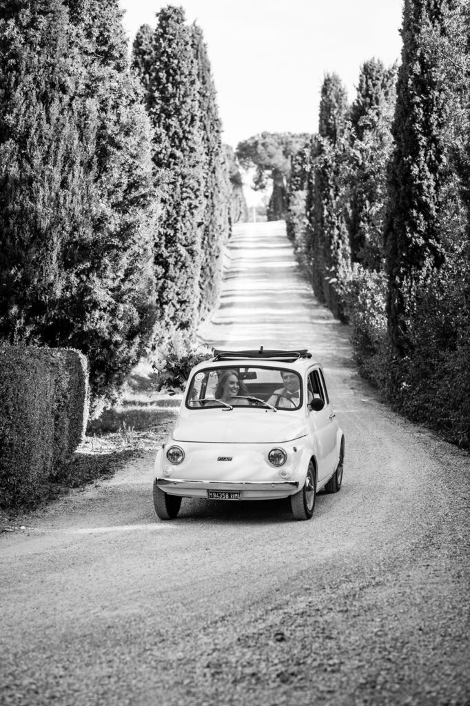 Vintage Fiat 500 on cypress-lined road, Italian wedding, black and white