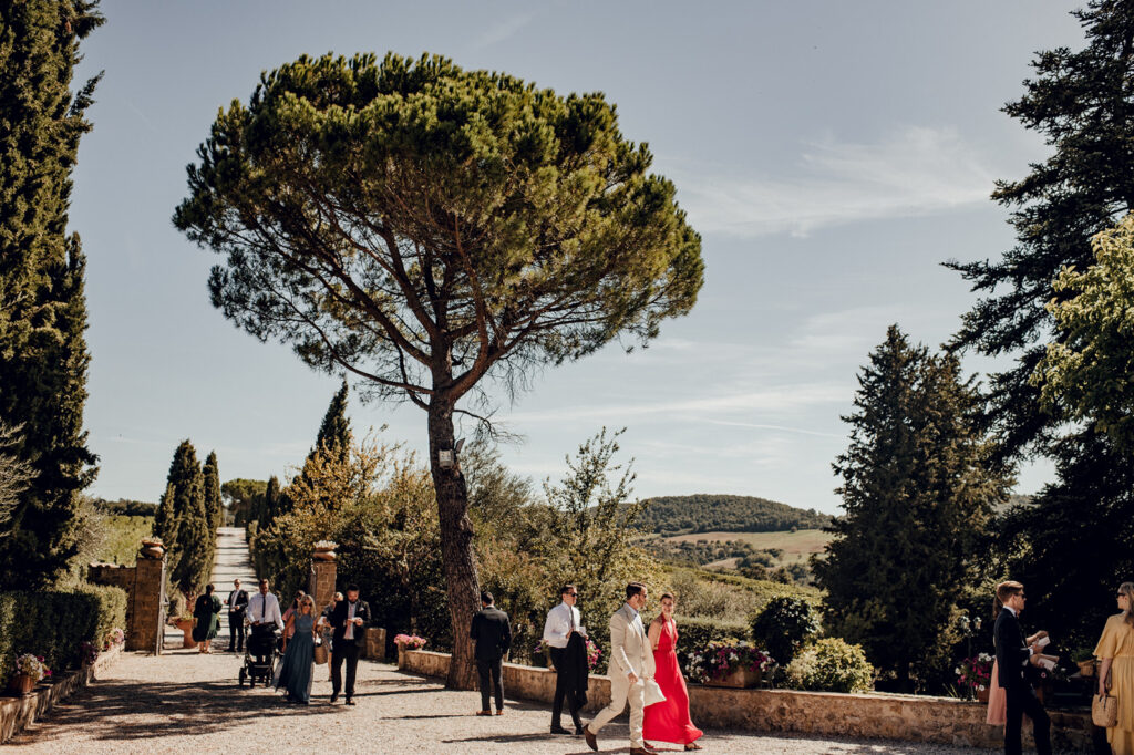 Wedding guests arriving at stone villa with bell tower, Tuscany