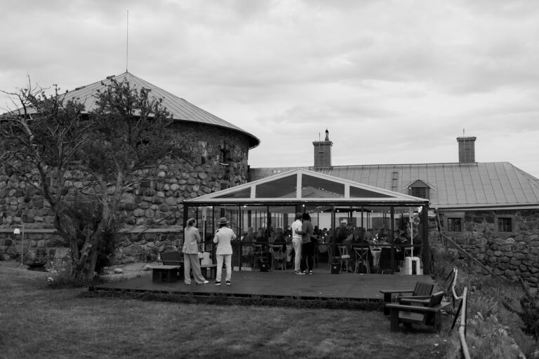 Wedding at Dalarö Skans: a photographer's guide 2 Dalarö Skans huvudbyggnad sedd utifrån med stenmur och skärgården i bakgrunden, svartvitt
