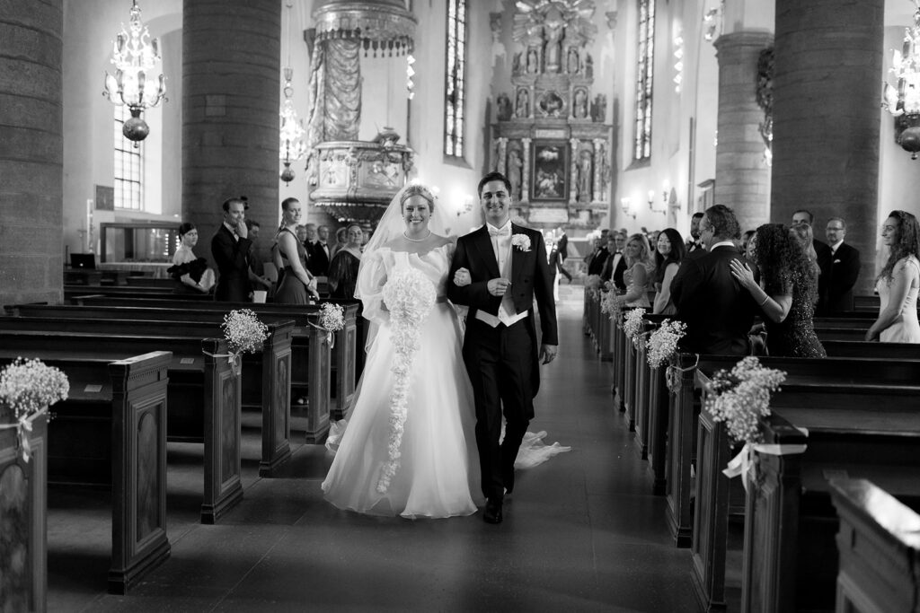 Getting married in Sweden: paperwork and planning 5 Brudpar går ut ur kyrka efter vigsel, svartvitt