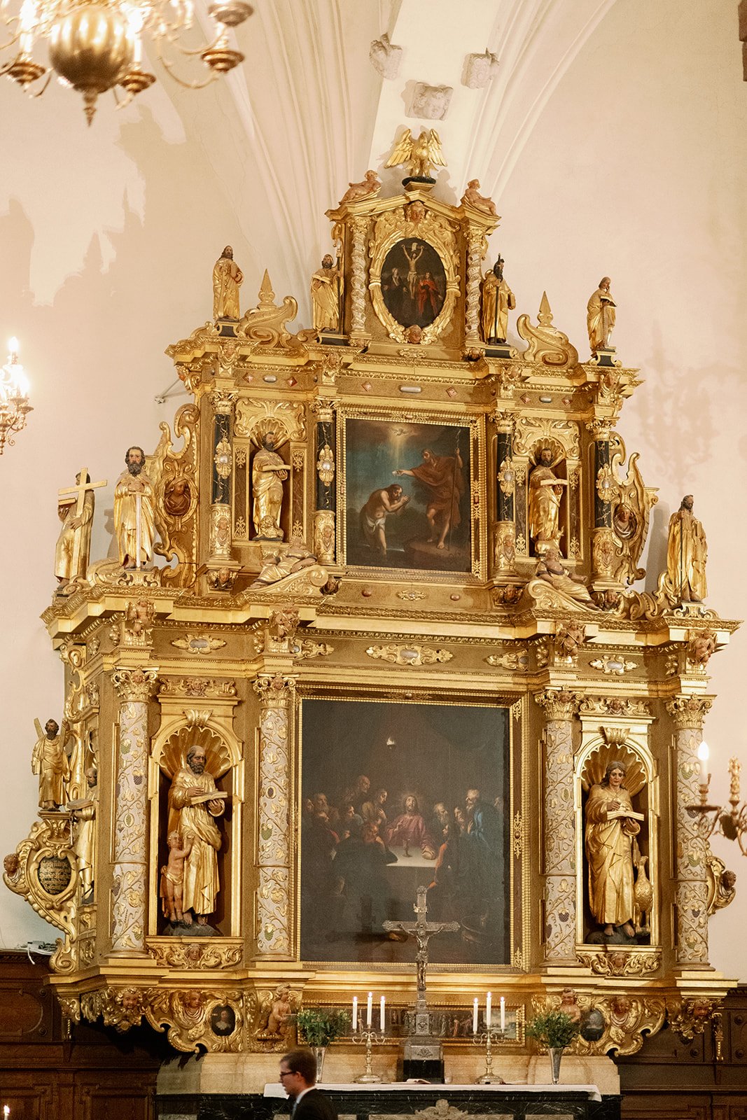 Gyllene altaruppsats med skulpturer och ljus i Stockholms kyrka