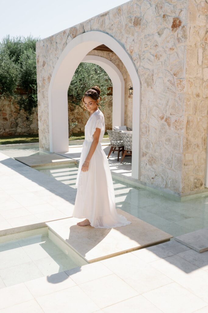 Bride walking on a stone terrace in the summer sun