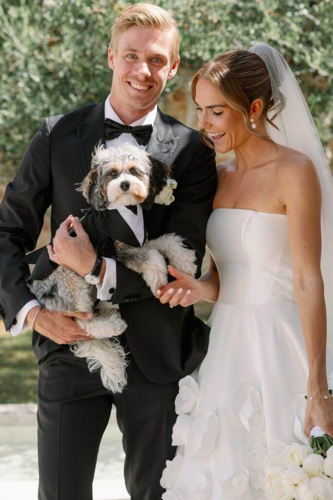 Bride and groom holding their small dog on the wedding day