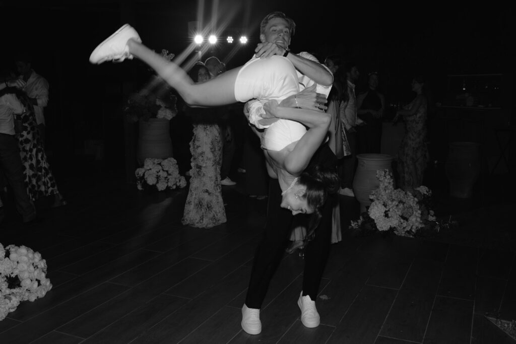Black and white photograph of a guest dancing at the wedding reception