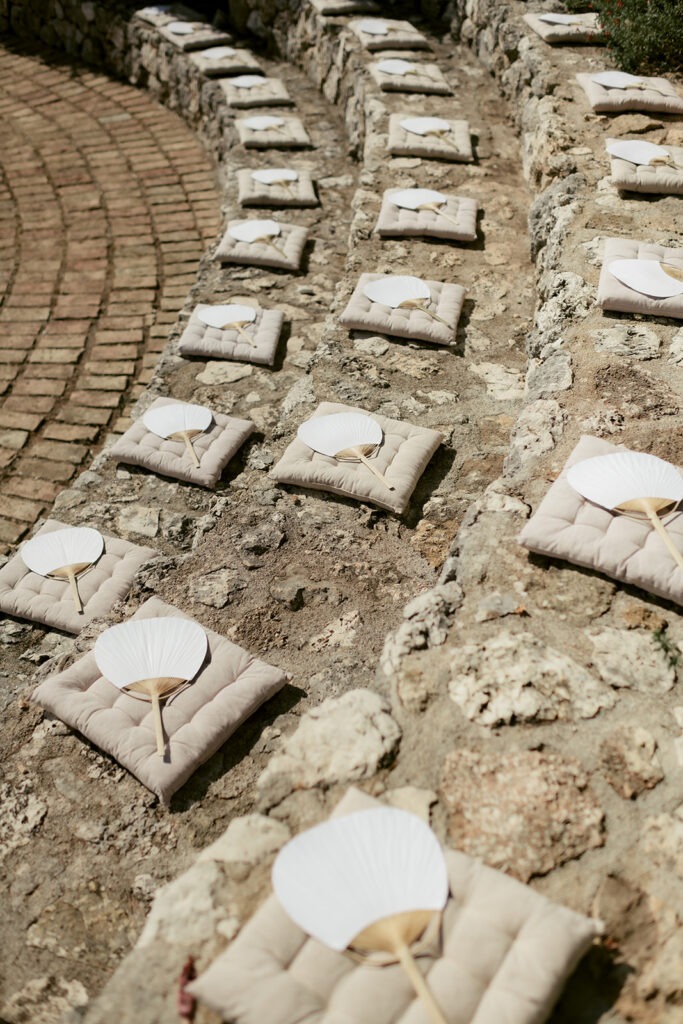 Cushions and paper fans laid out for the guests on the stone terrace before the ceremony, Kefalonia