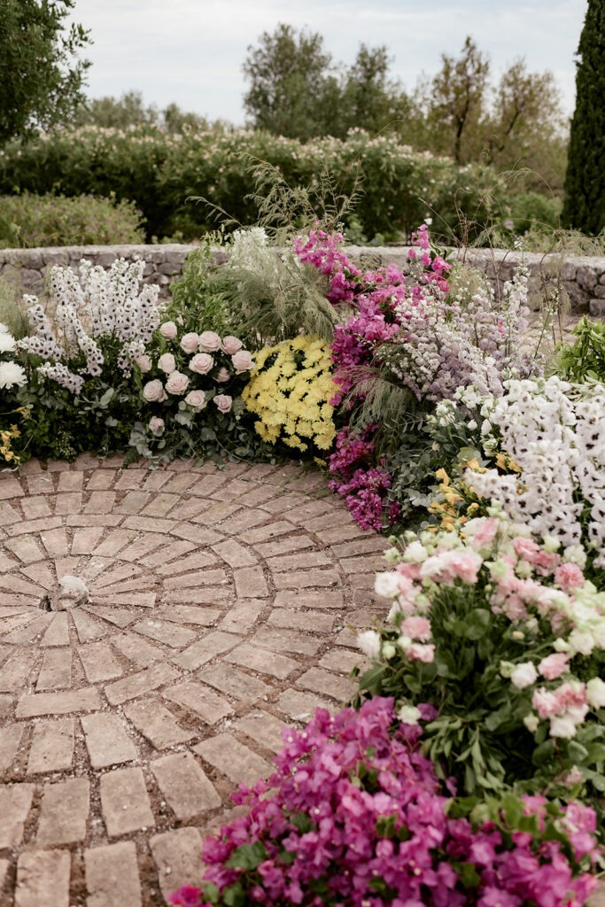 Pink and white flowers along the edge of the stone ceremony terrace on Kefalonia