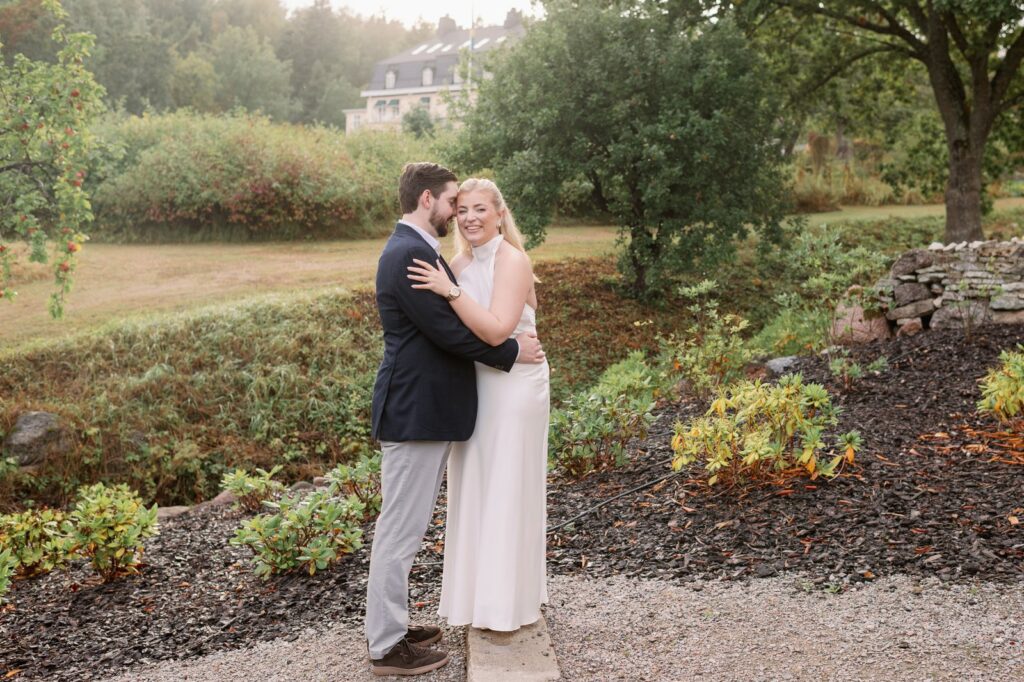 Bröllop på Villa Fridhem: en fotografs guide 17 Brudparet kramas på en grusgång bland planteringarna i parken