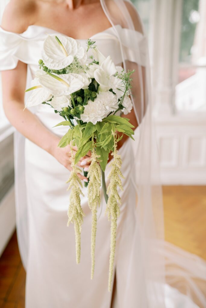 Wedding at Thorskogs Slott 26 Bridal bouquet of white flowers and trailing green amaranthus against the wedding dress