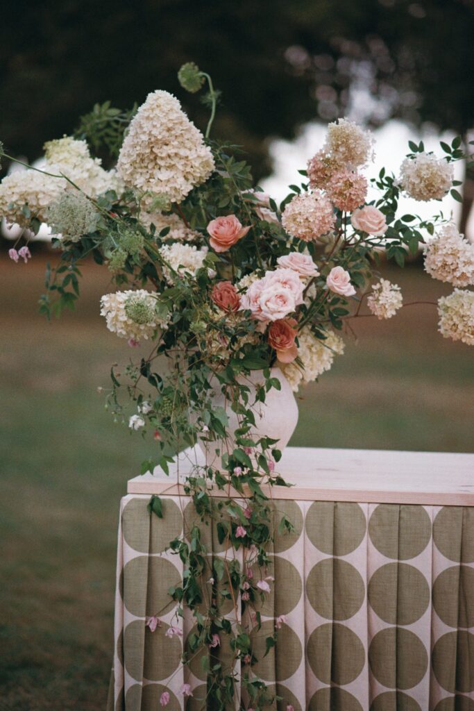 White and pink flowers on a table with a patterned cloth, shot on 35mm film