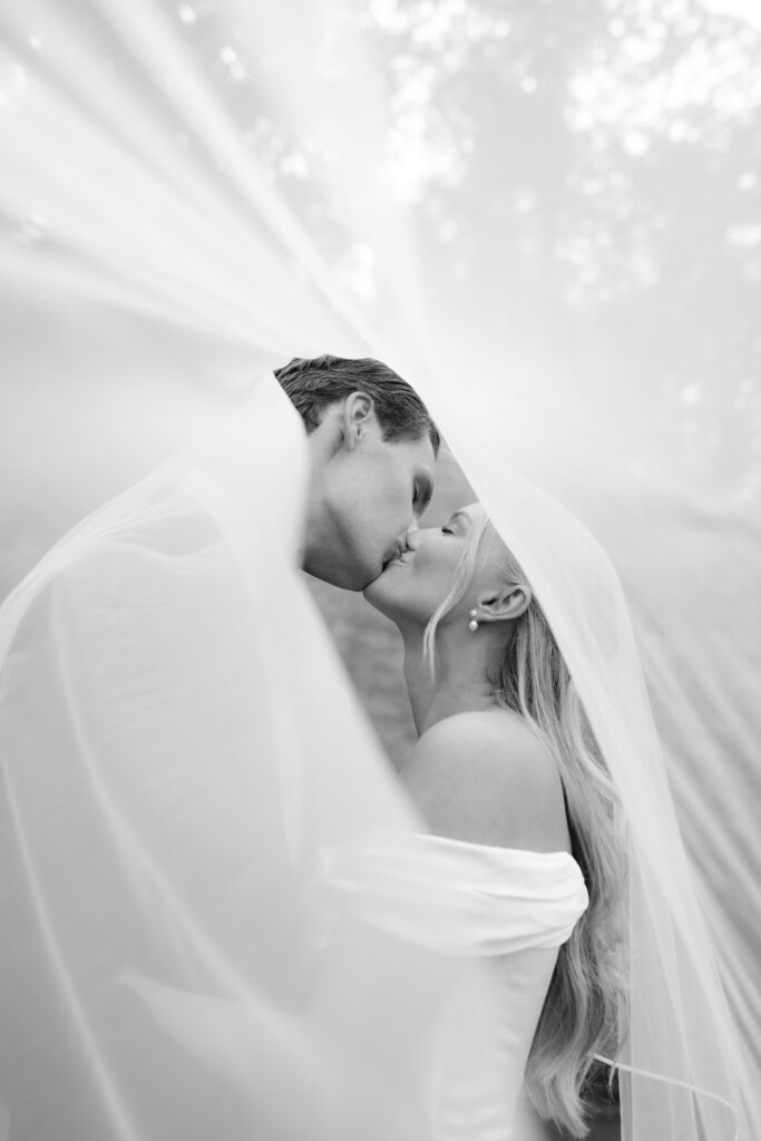Wedding at Thorskogs Slott 18 Black and white close-up: the couple kisses inside the veil