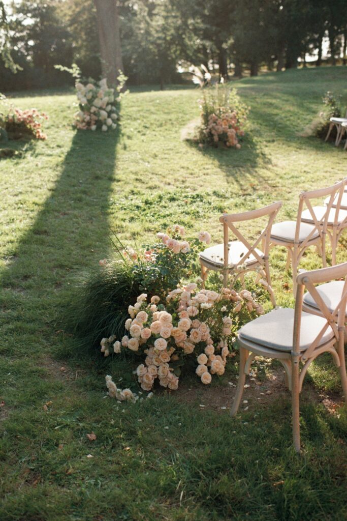 Long shadows across the lawn and a floral arrangement at the end of a row of chairs, shot on 35mm film