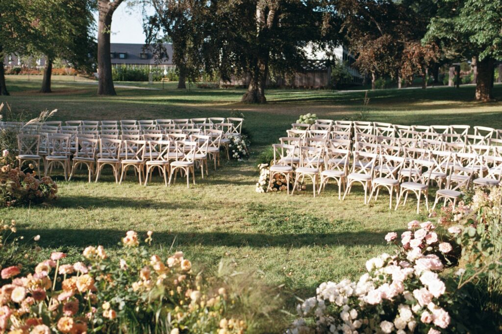 Curved rows of chairs seen from behind, flowers in the foreground, shot on 35mm film