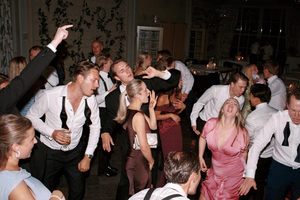 Wedding at Thorskogs Slott 17 A packed dance floor with guests jumping and singing, shot on 35mm film