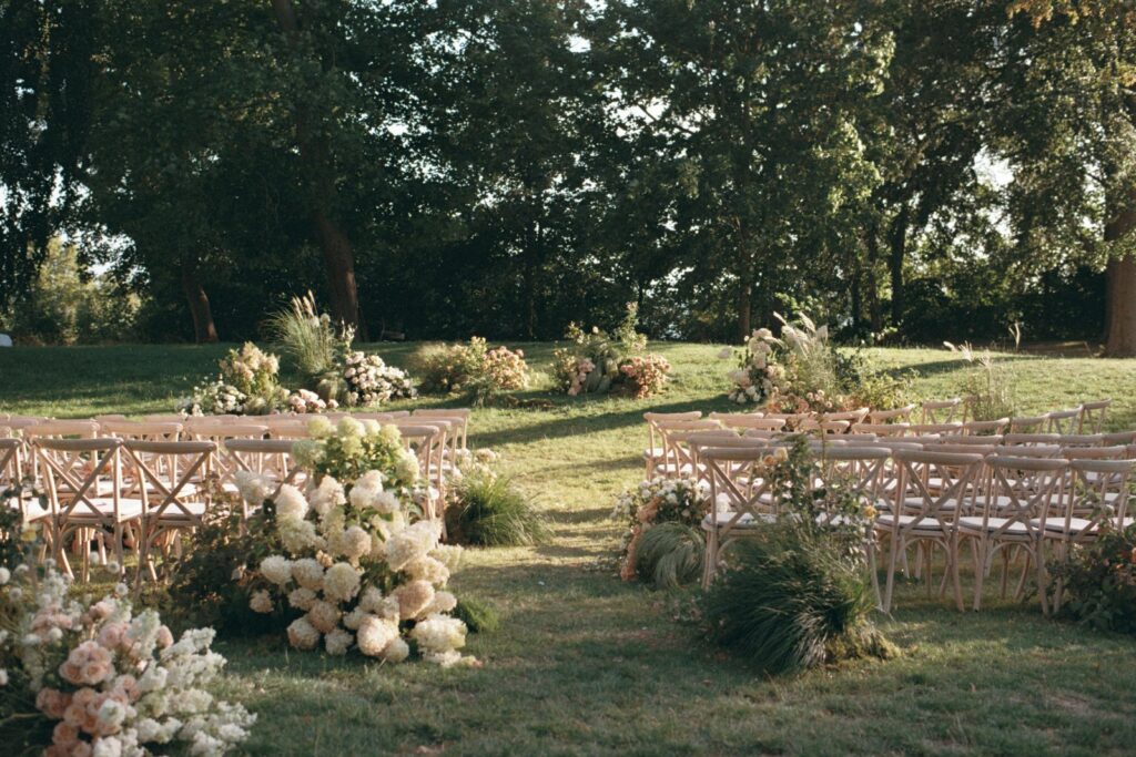 White hydrangeas and grasses by the rows of chairs at the ceremony in the park, shot on 35mm film