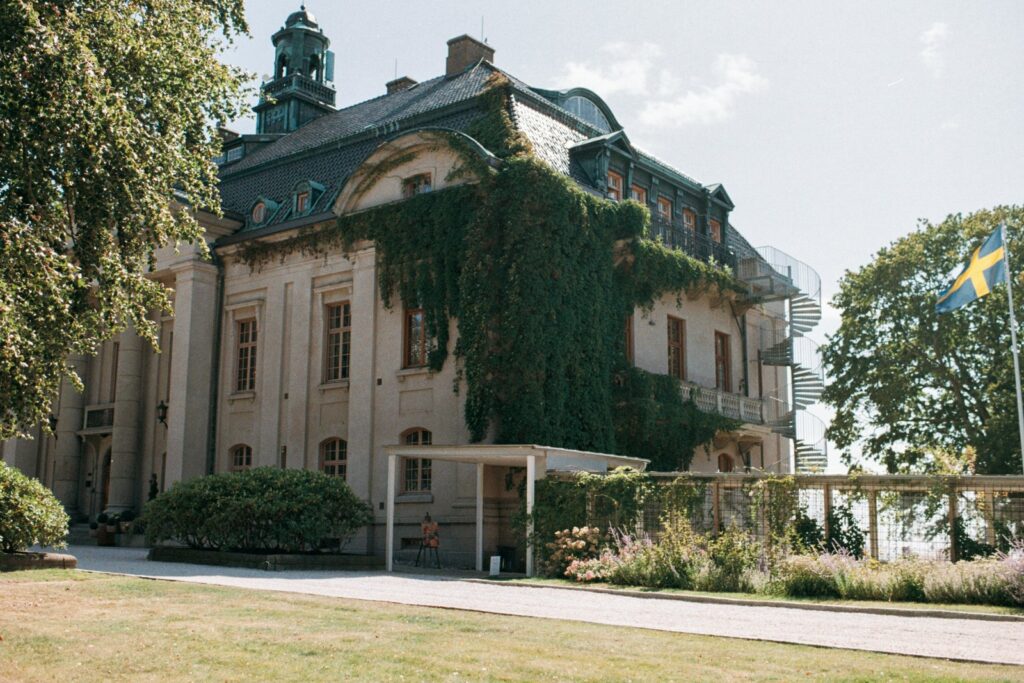 The ivy-covered castle facade with its tower and a Swedish flag at the corner, shot on 35mm film