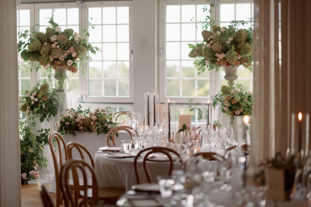 Bröllop på Villa Fridhem: en fotografs guide 21 Matsalen dukad med runda bord och blommor framför höga spröjsade fönster