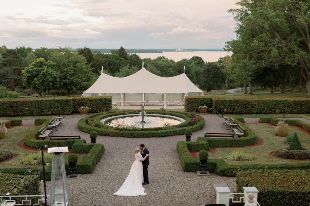The couple in the formal garden with the fountain and Bråviken bay behind