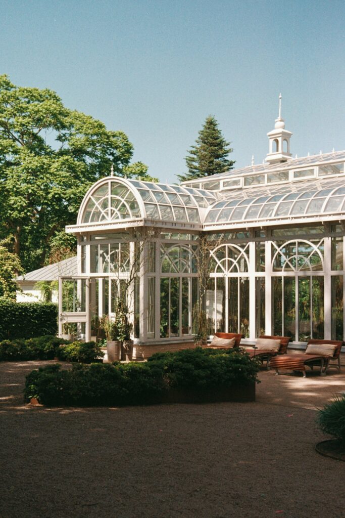 Wedding at Norrvikens trädgårdar 40 Victoriahuset at Norrvikens trädgårdar in sunshine, domed glass roof and lounge furniture in front, shot on 35mm film